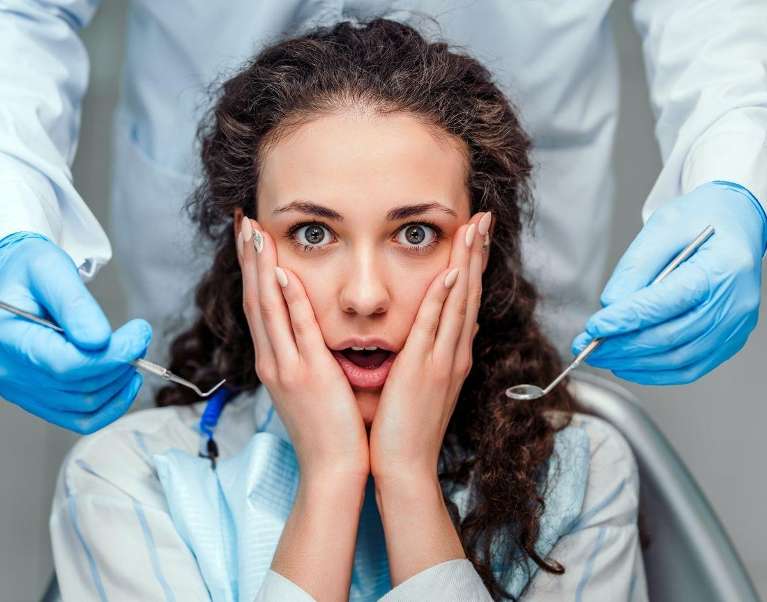 Woman with hands on face at dentist, glendale ca